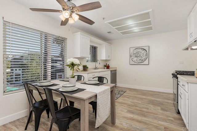 a kitchen with stainless steel appliances a stove a sink cabinets and wooden floor