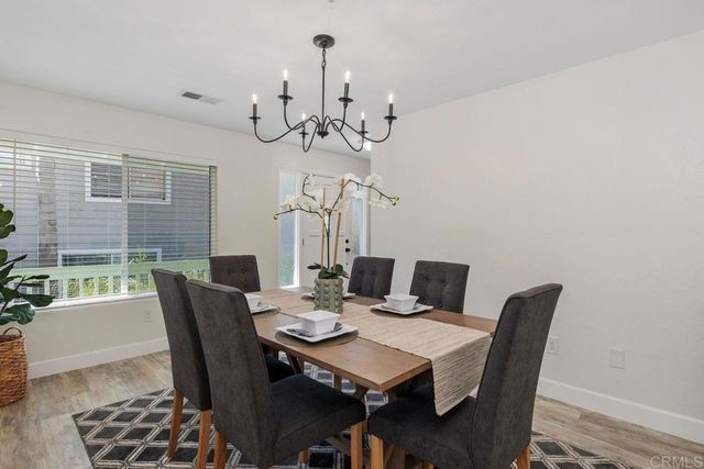 a spacious bedroom with a bed a couch and potted plant on the dresser