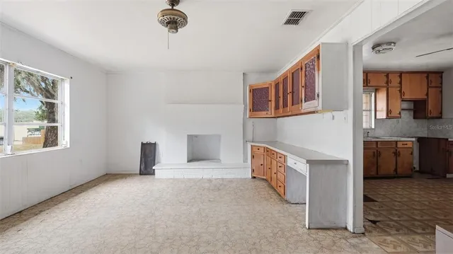 a view of an empty room with a fireplace and a window