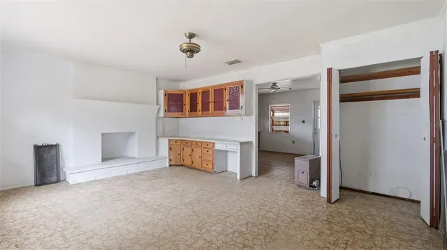 a view of an empty room with closet and windows