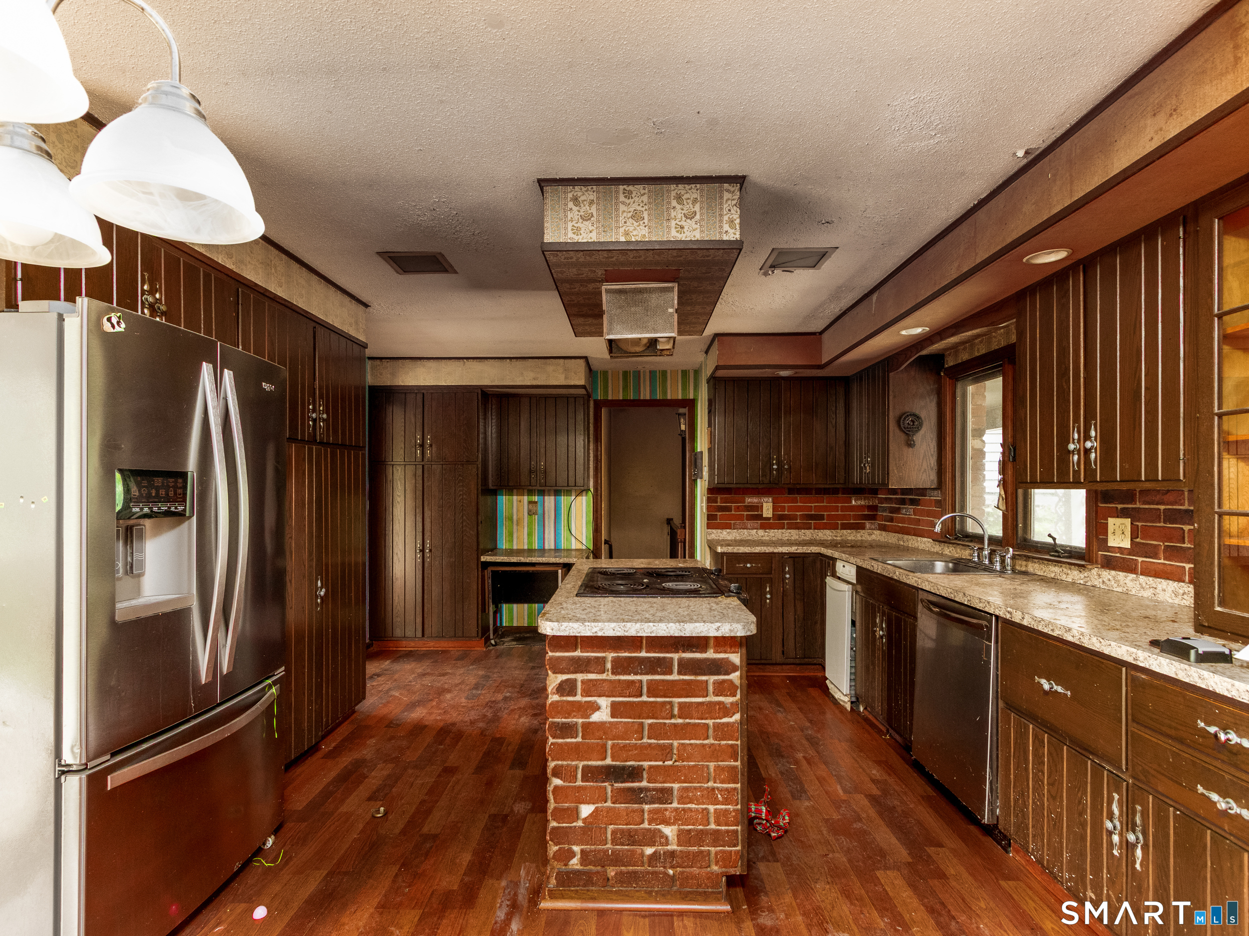 63 High Hill Road Wallingford, CT 06492 - Photo 15 of 34 a kitchen with stainless steel appliances granite countertop a refrigerator a sink dishwasher a stove and a dining table with wooden floor