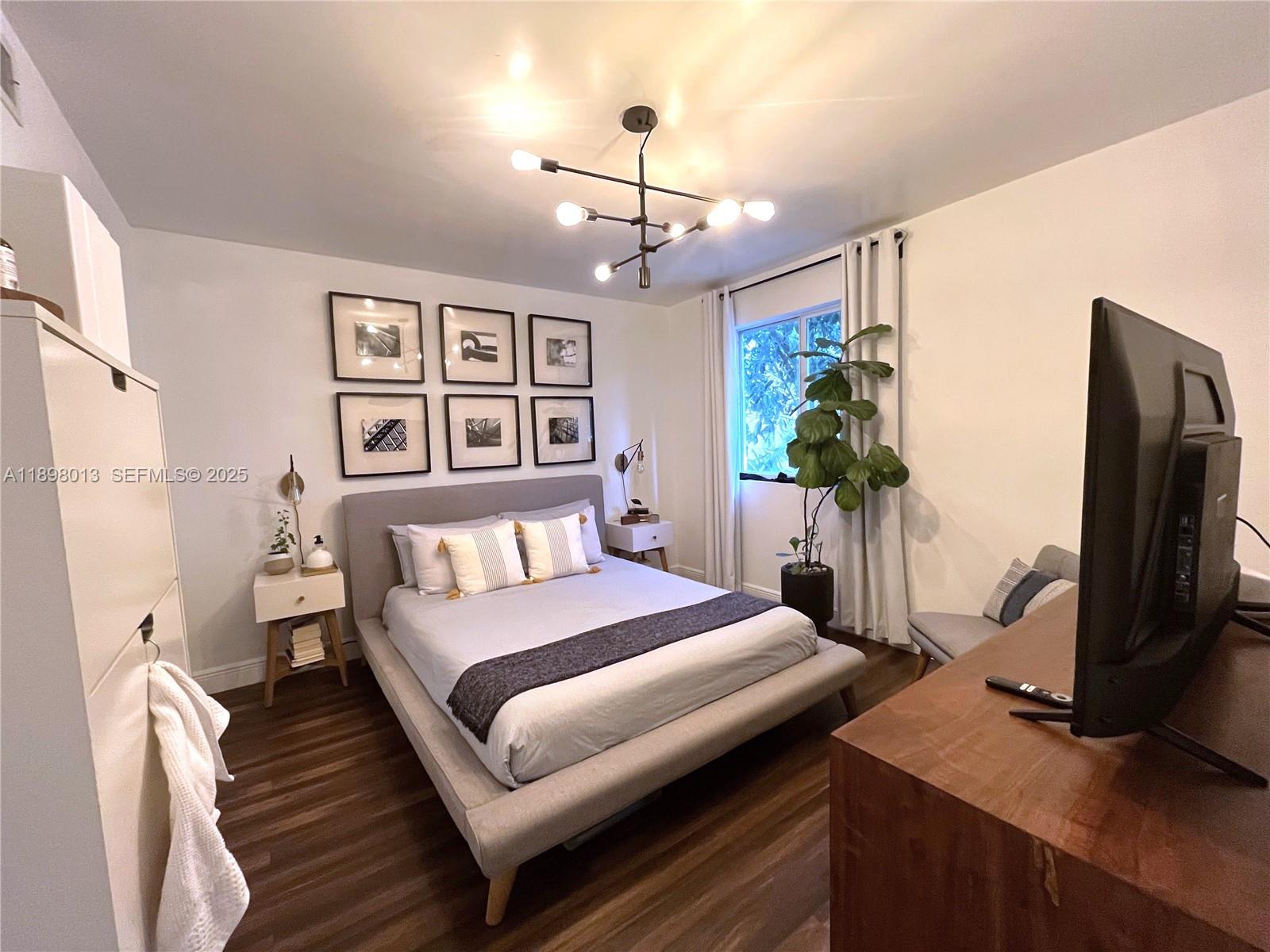 540 Northwest 7th Street, Unit 26 Miami, FL 33136 - Photo 4 of 7 a bedroom with a bed window and a flat screen television