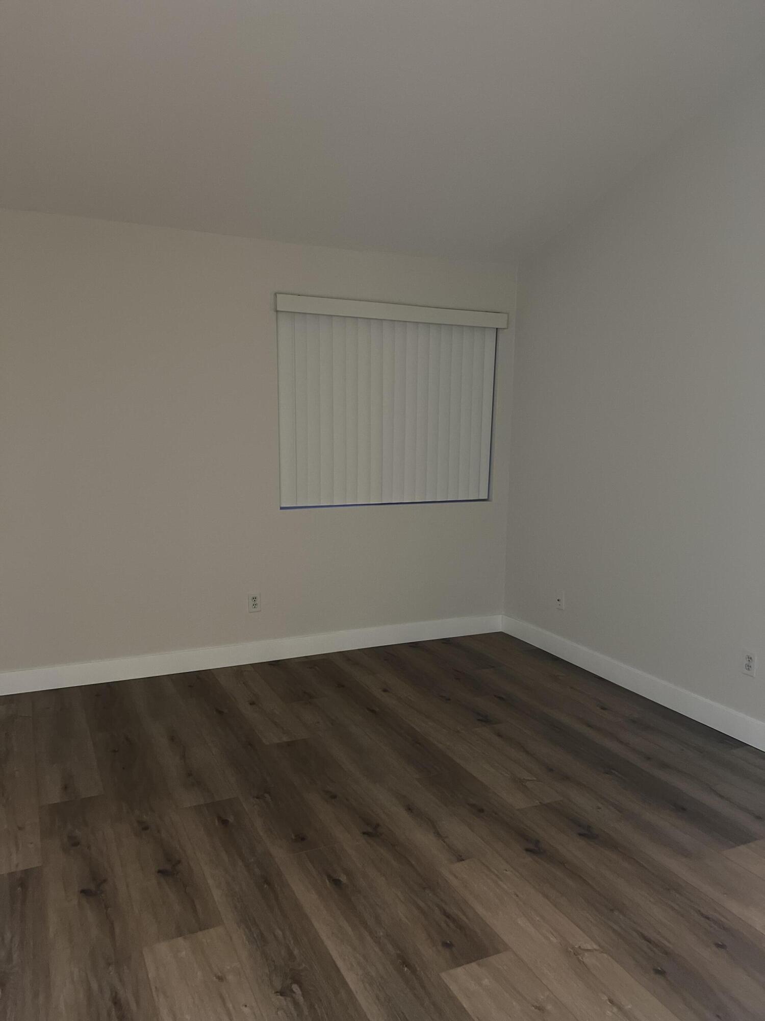 79307 South Sunset Ridge Drive La Quinta, CA 92253 - Photo 14 of 32 an empty room with wooden floor and windows