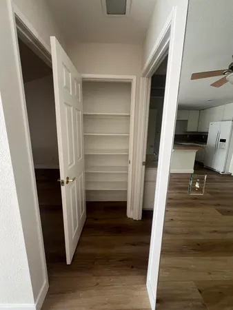 a view of empty room with wooden floor