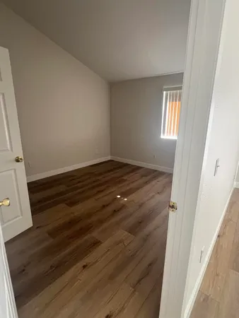 an empty room with wooden floor and closet