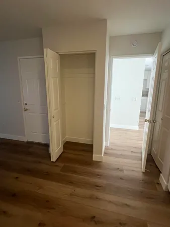 a view of an empty room with wooden floor