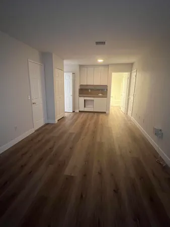 a kitchen with granite countertop white cabinets and a sink