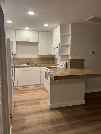 a view of a refrigerator in kitchen and wooden floor