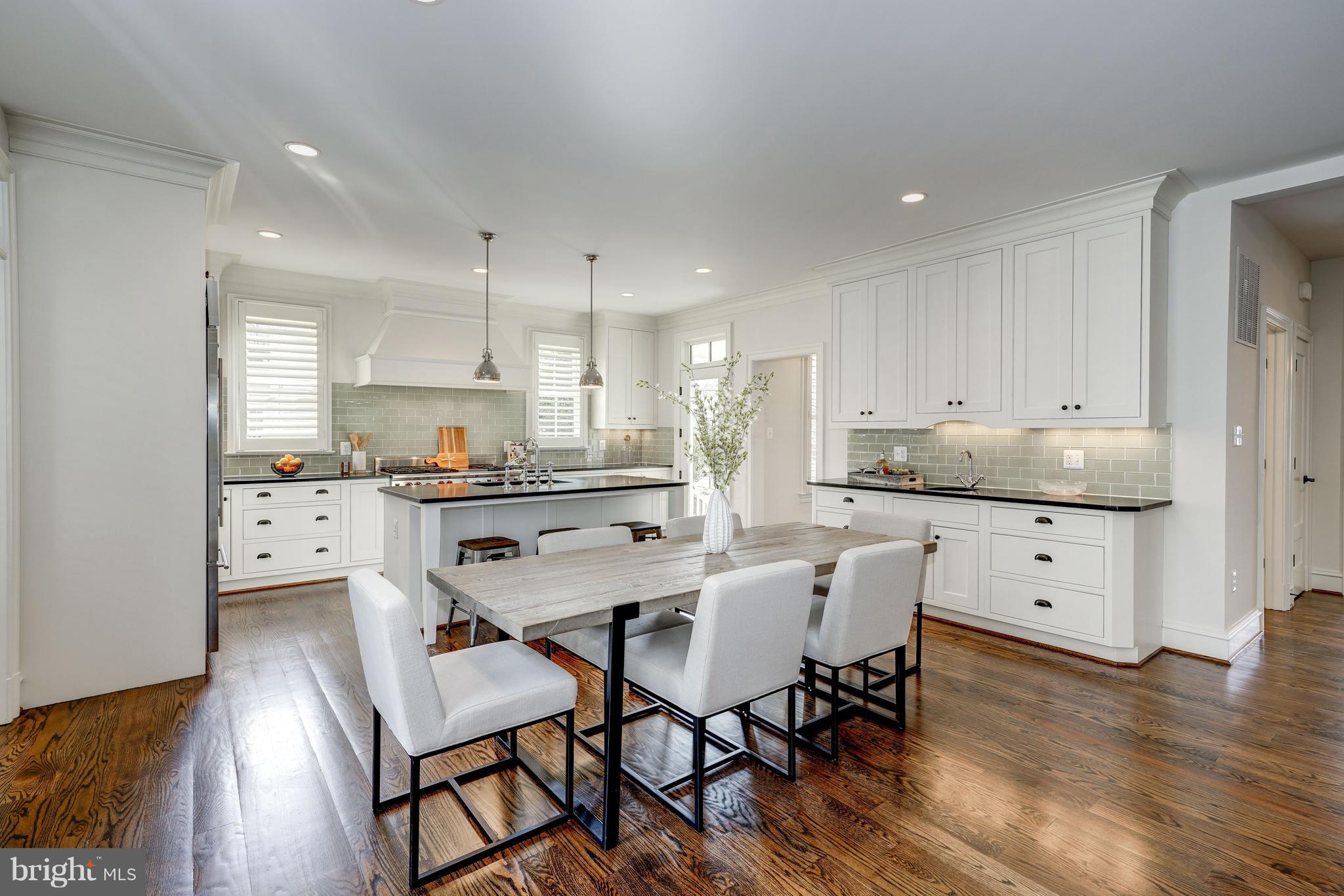 3007 North Rochester Street Arlington, VA 22213 - Photo 12 of 43 a kitchen with stainless steel appliances kitchen island granite countertop a dining table chairs and white cabinets