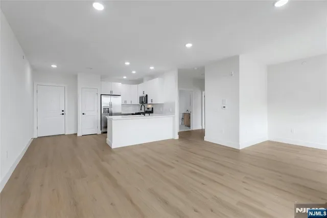 a view of kitchen with kitchen island wooden floor center island and stainless steel appliances