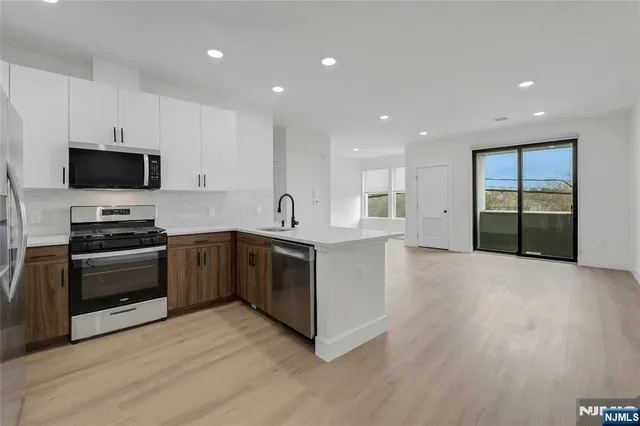 a large kitchen with stainless steel appliances and a stove top oven