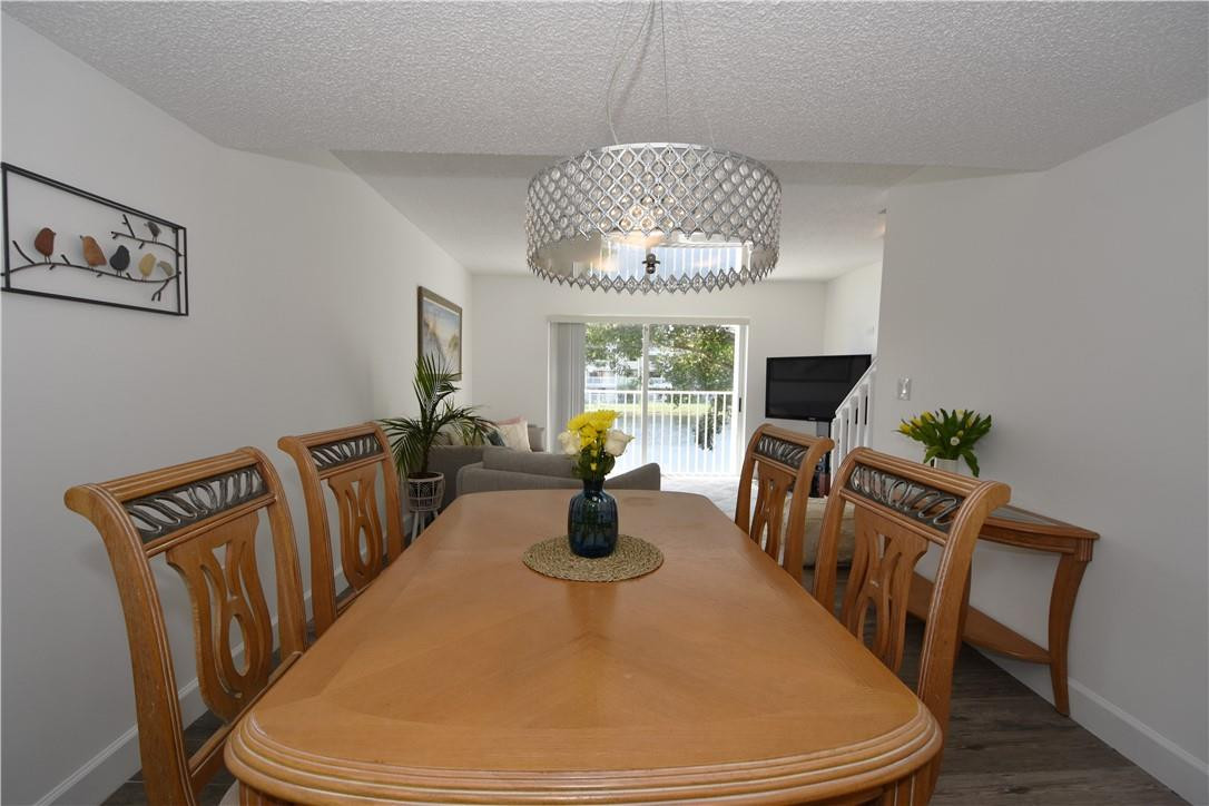 217 Riviera Circle, Unit 217 Weston, FL 33326 - Photo 16 of 58 a dining room with furniture a chandelier and wooden floor