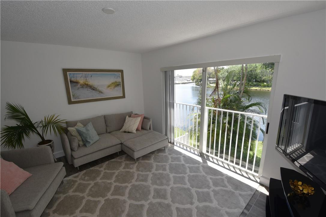 217 Riviera Circle, Unit 217 Weston, FL 33326 - Photo 17 of 58 a living room with furniture a flat screen tv and a floor to ceiling window