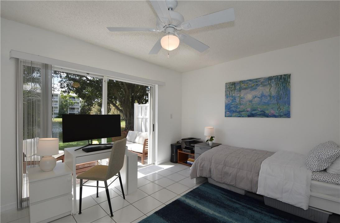 217 Riviera Circle, Unit 217 Weston, FL 33326 - Photo 41 of 58 a living room with furniture a flat screen tv and a floor to ceiling window