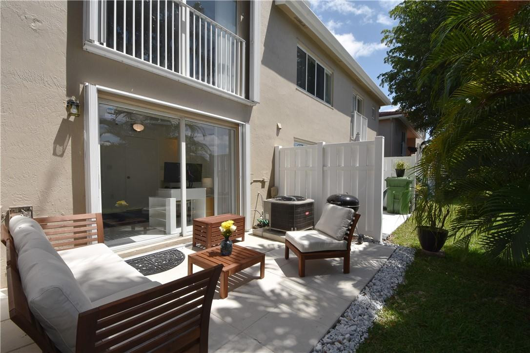 217 Riviera Circle, Unit 217 Weston, FL 33326 - Photo 49 of 58 a view of a patio with couches table and chairs and garden