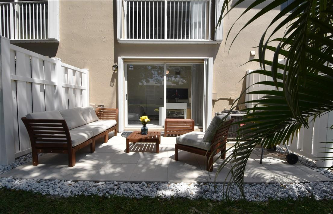 217 Riviera Circle, Unit 217 Weston, FL 33326 - Photo 50 of 58 a view of a patio with couches table and chairs and potted plants
