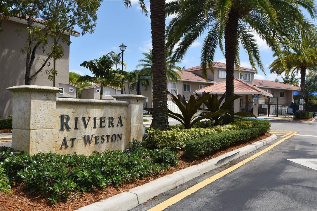217 Riviera Circle, Unit 217 Weston, FL 33326 - Photo 53 of 58 a sign that is on a brick wall with a large building in the background
