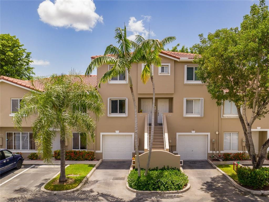 217 Riviera Circle, Unit 217 Weston, FL 33326 - Photo 56 of 58 a front view of a house with a yard and potted plants