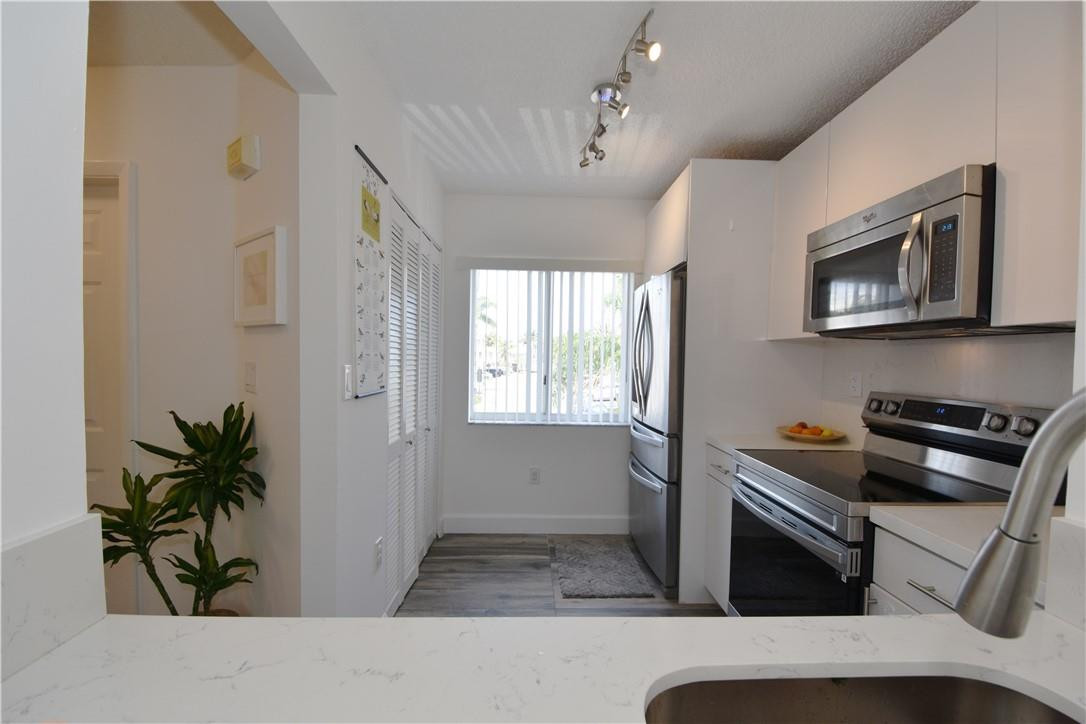 217 Riviera Circle, Unit 217 Weston, FL 33326 - Photo 10 of 58 a kitchen that has a microwave and a stove in it