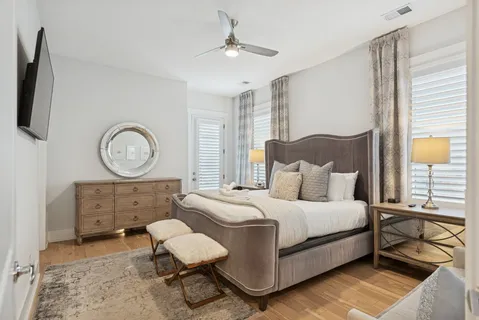 a bedroom with a bed a mirror on dresser and a chandelier