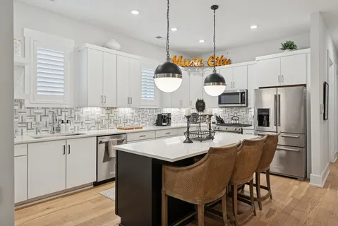 a kitchen with stainless steel appliances granite countertop a sink a stove a refrigerator and island