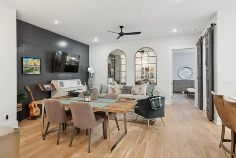 a living room with furniture a flat screen tv and a large window
