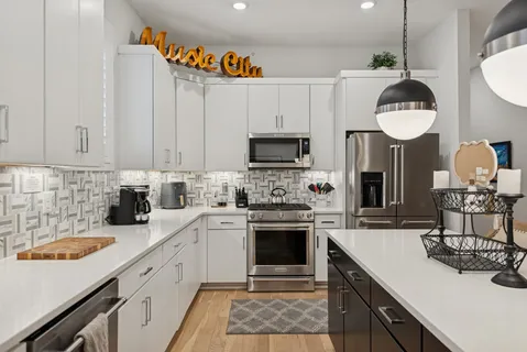 a kitchen with a sink stainless steel appliances and white cabinets
