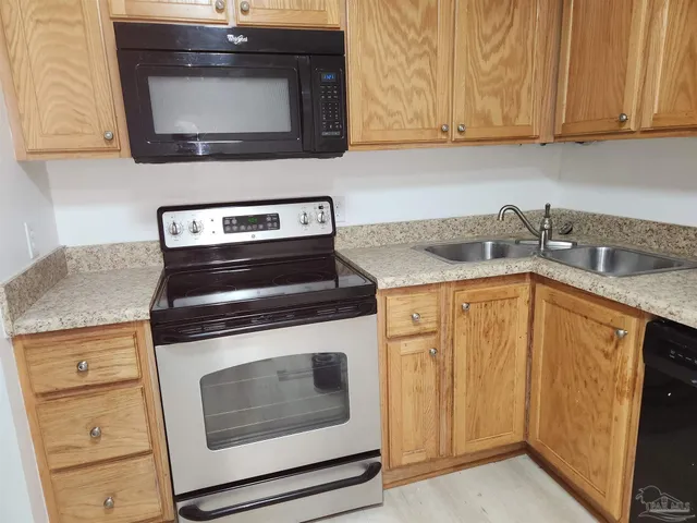 a kitchen with stainless steel appliances granite countertop a stove microwave and sink