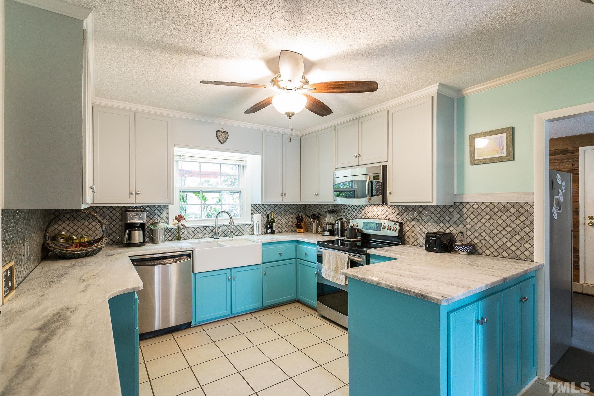 3213 Manor Ridge Drive Raleigh, NC 27603 - Photo 17 of 32 a kitchen with a stove sink and cabinets