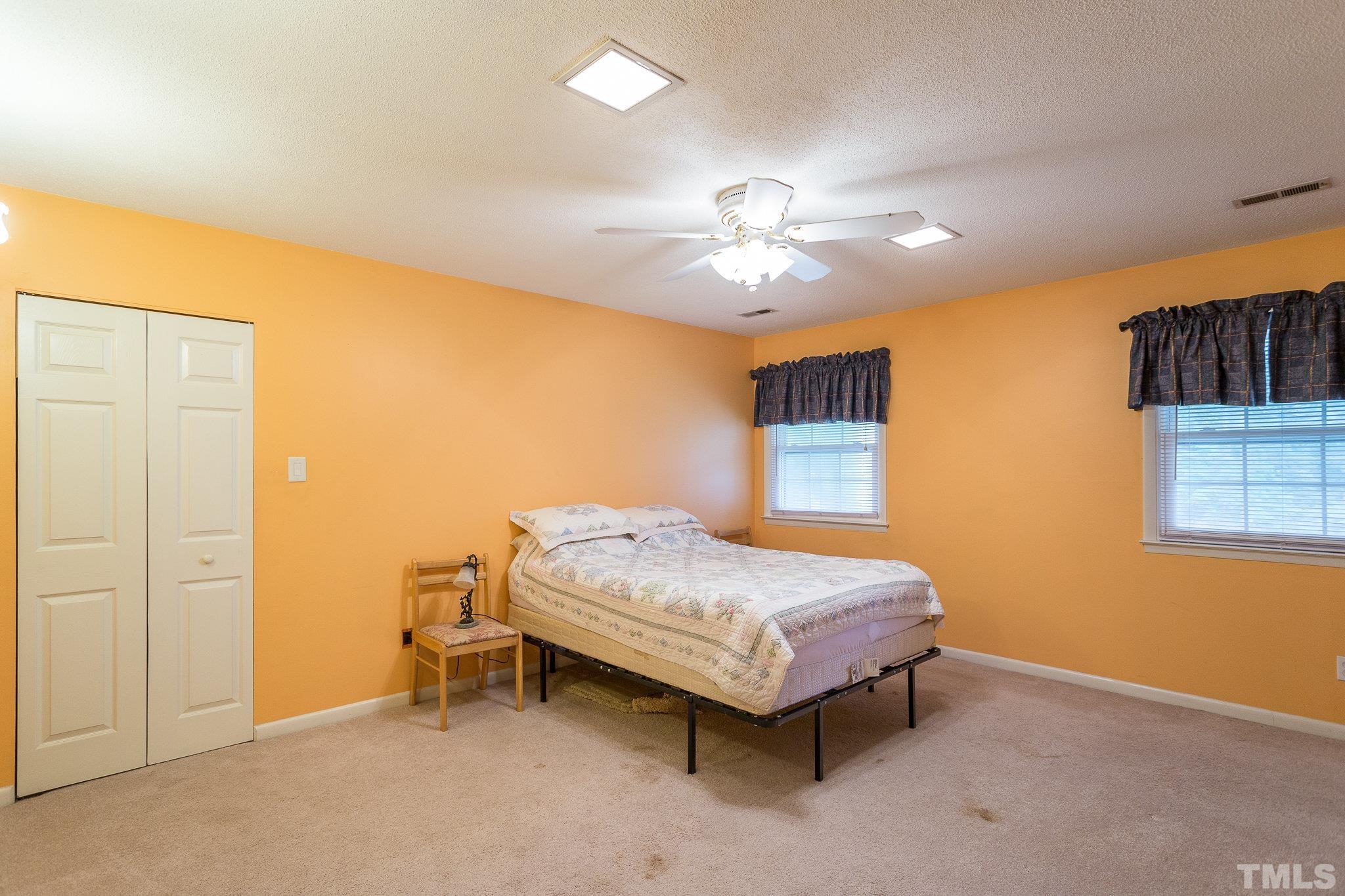 3213 Manor Ridge Drive Raleigh, NC 27603 - Photo 23 of 32 a bedroom with a bed and a chandelier