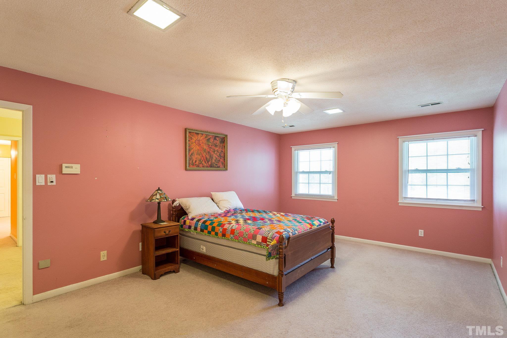 3213 Manor Ridge Drive Raleigh, NC 27603 - Photo 26 of 32 a bedroom with a bed and a chandelier