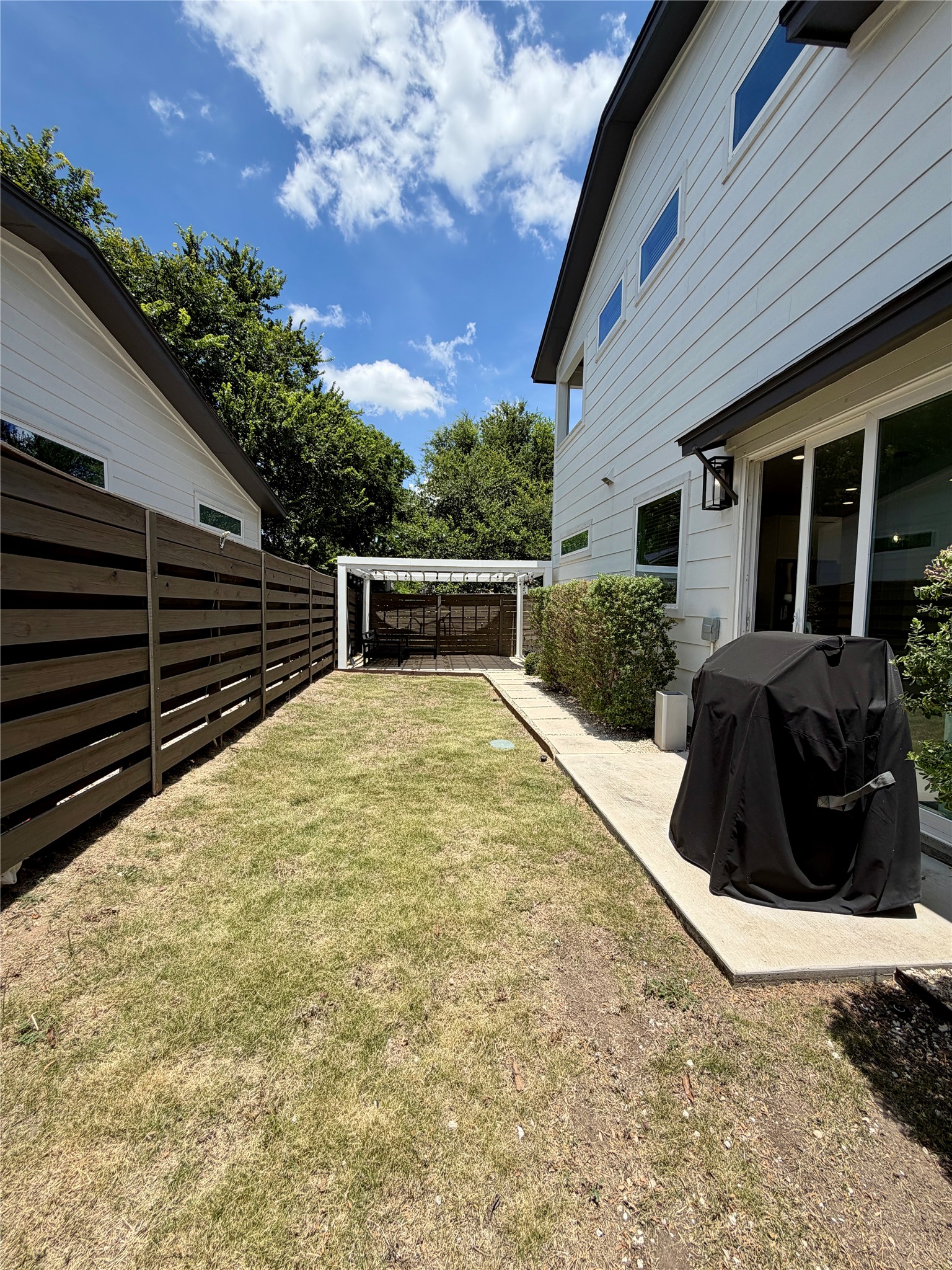 6102 Ponca Street, Unit 2 Austin, TX 78741 - Photo 24 of 24 A backyard sanctuary with a spacious lawn and an inviting pergola, perfect for quiet enjoyment.