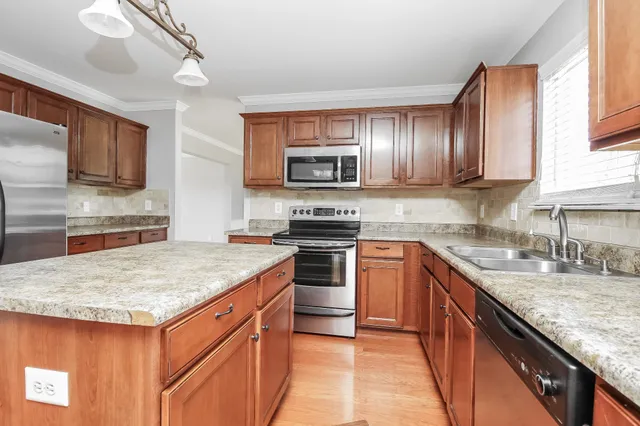 a kitchen with granite countertop stainless steel appliances and stove top oven