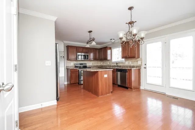 a kitchen with kitchen island a sink a stove and a window