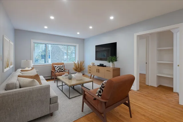 a living room with furniture a flat screen tv and a large window