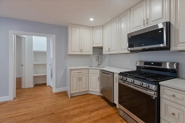 a kitchen with stainless steel appliances a stove a microwave and cabinets
