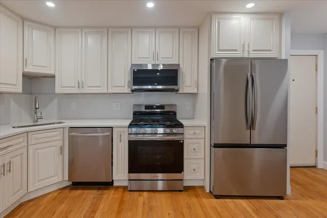 a kitchen with a refrigerator stove and white cabinets