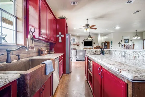 a kitchen with stainless steel appliances granite countertop a sink and a refrigerator