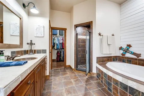 a spacious bathroom with a tub sink and mirror