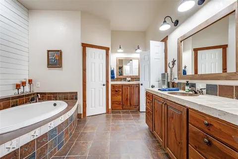 a spacious bathroom with a granite countertop tub sink and mirror