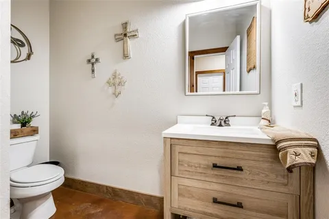 a bathroom with a granite countertop sink toilet and mirror