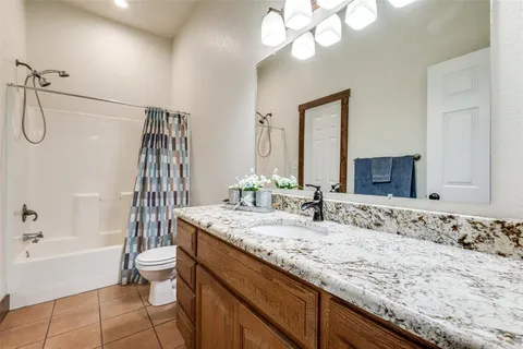 a bathroom with a granite countertop sink a toilet and bathtub