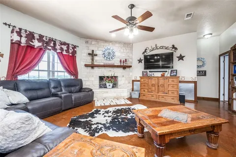 a living room with furniture a flat screen tv and a chandelier