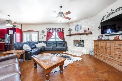 a living room with furniture a flat screen tv and kitchen view