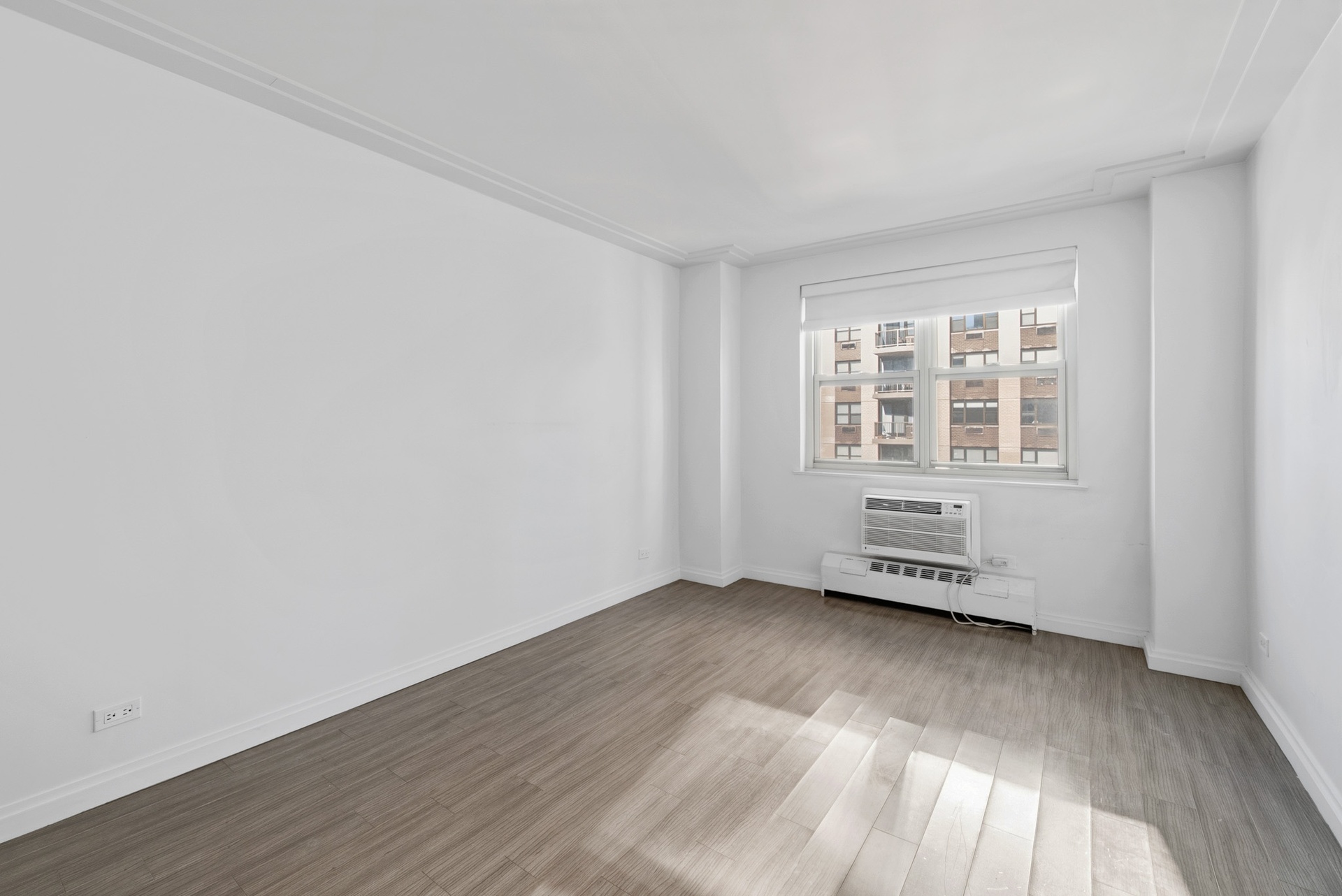 340 East 80th Street, Unit 17D Manhattan, NY 10075 - Photo 13 of 18 an empty room with wooden floor and windows