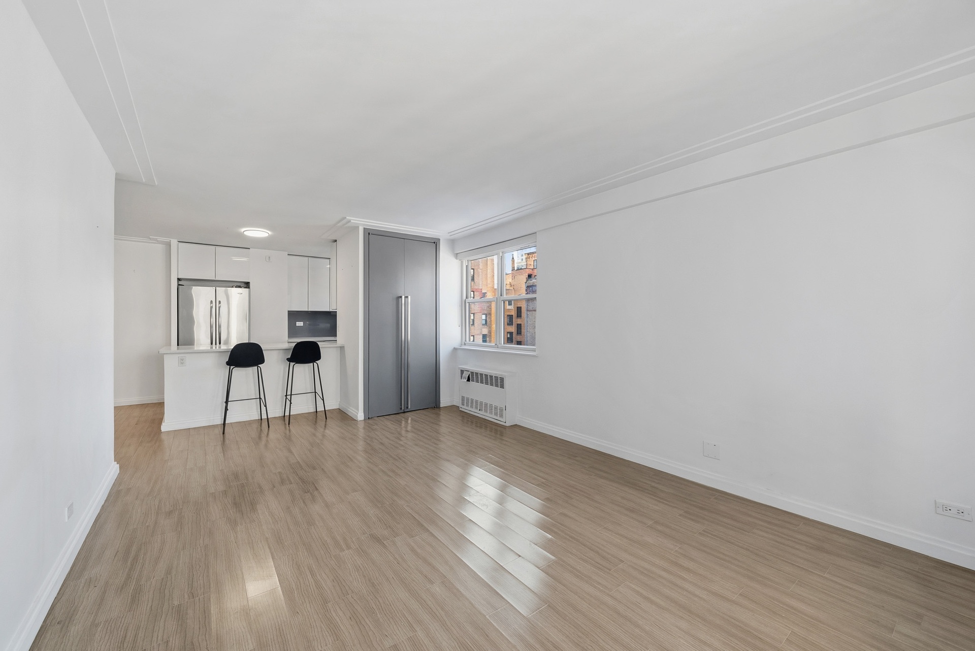 340 East 80th Street, Unit 17D Manhattan, NY 10075 - Photo 5 of 18 a view of an empty room with wooden floor and a window
