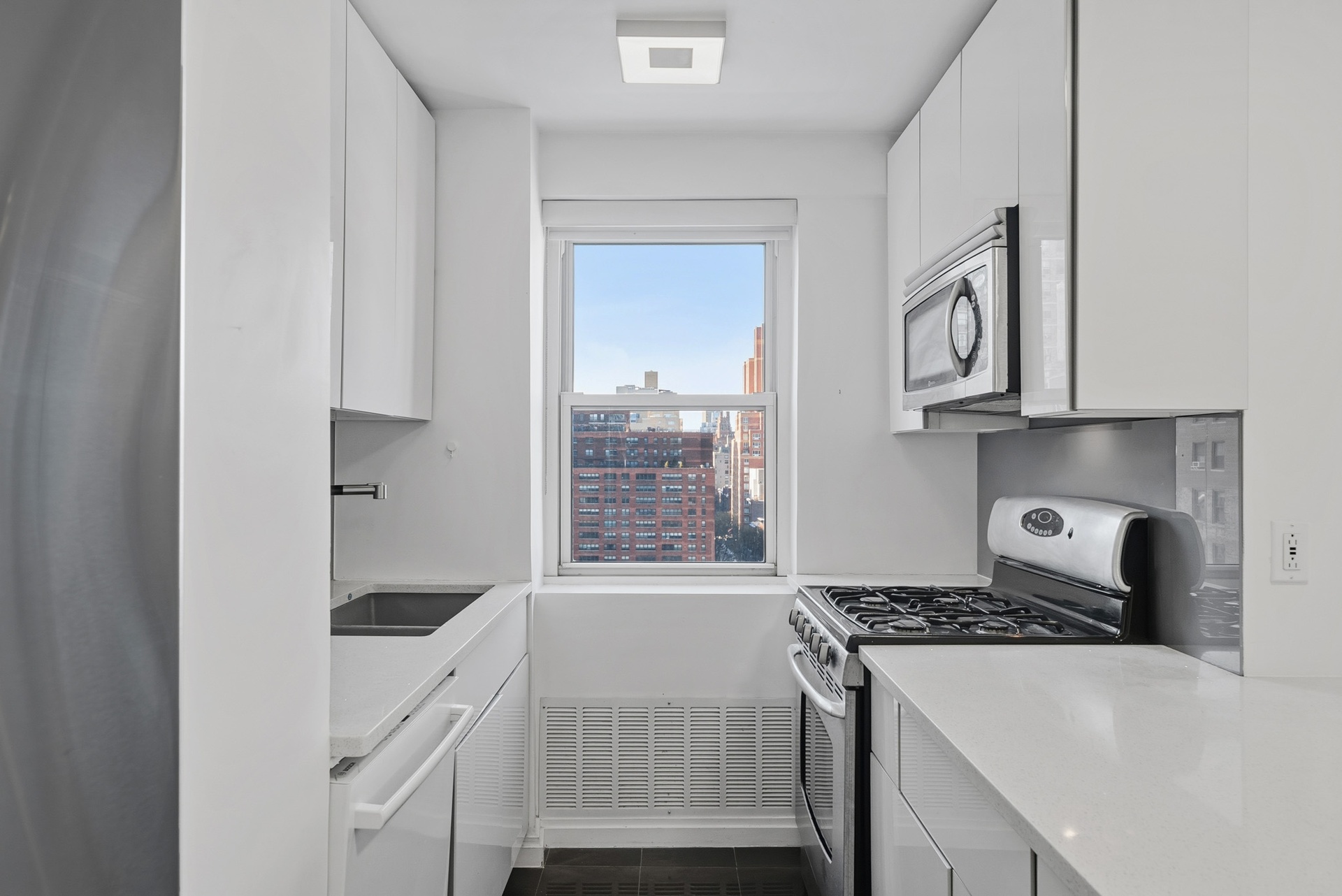 340 East 80th Street, Unit 17D Manhattan, NY 10075 - Photo 7 of 18 a kitchen with a stove and white cabinets