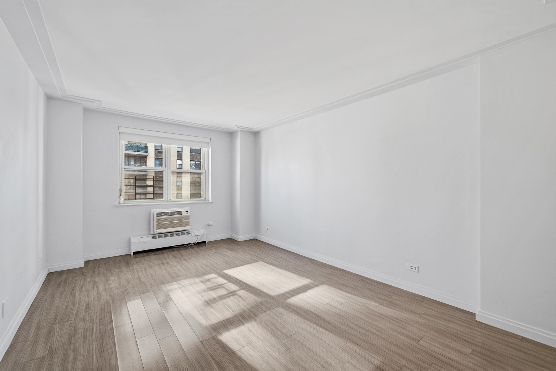 340 East 80th Street, Unit 17D Manhattan, NY 10075 - Photo 9 of 18 an empty room with wooden floor and windows