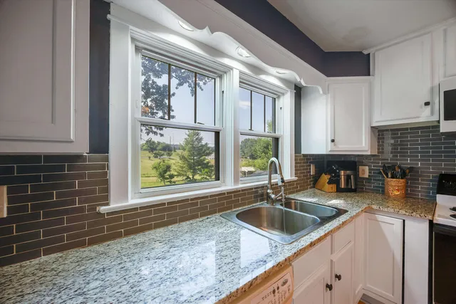 a kitchen with a sink a stove and cabinets