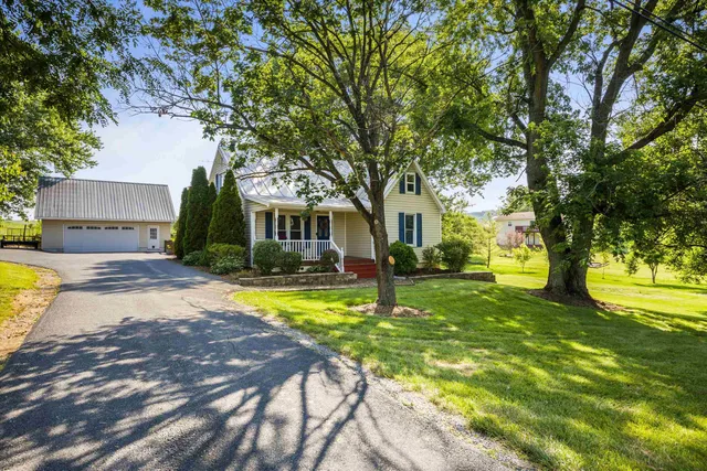 a view of a house with swimming pool and a large tree
